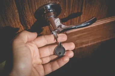 Mann holder oppbrutt nøkkel med lås