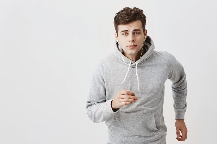 Stilig europeisk ung mann iført en trendy grå hettegenser